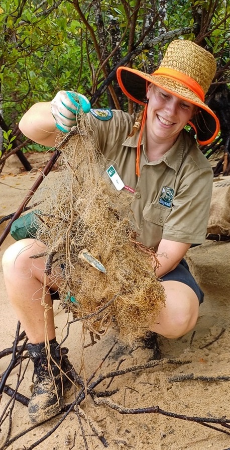 Close up of female ranger sitting on the beach with a discarded fishing net