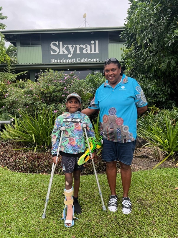 injured Child stands with his family in front of the Skyrail building