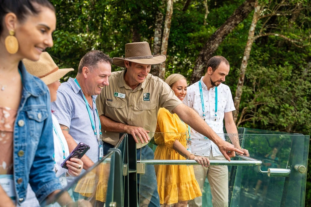 Skyrail Ranger and a group of delegates stand at the edge lookout, looking down the Gorge