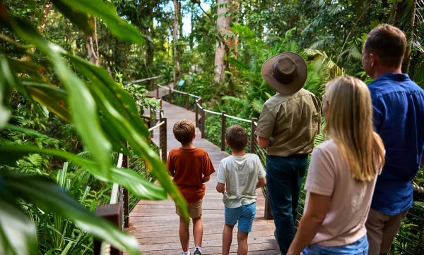 Young Family on the boardwalk with a Skyrail Ranger surrounded by lush rainforest