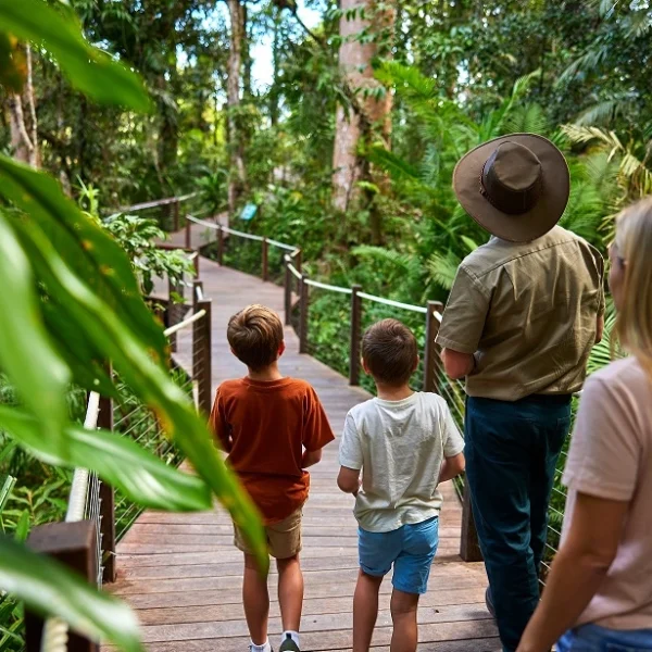 Young Family on the boardwalk with a Skyrail Ranger surrounded by lush rainforest
