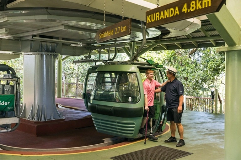 Guest with physical impairment boards the Skyrail gondola with assistance from his carer