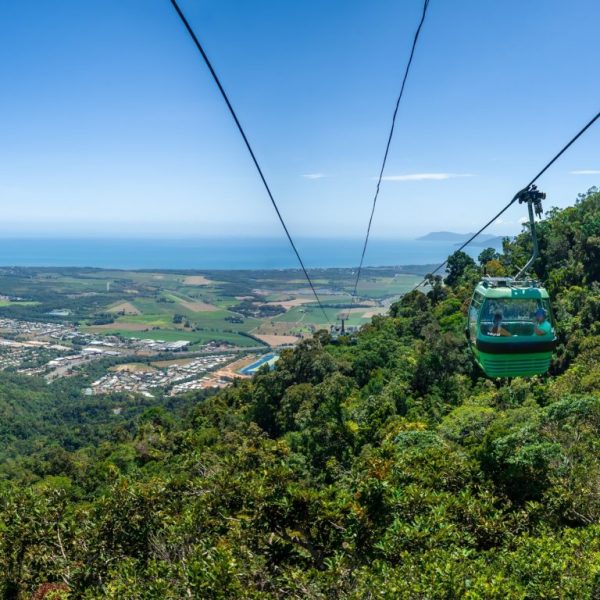 Skyrail gondola high above the wet tropics rainforest with clear blue skies and views all the way out over the Coral Sea