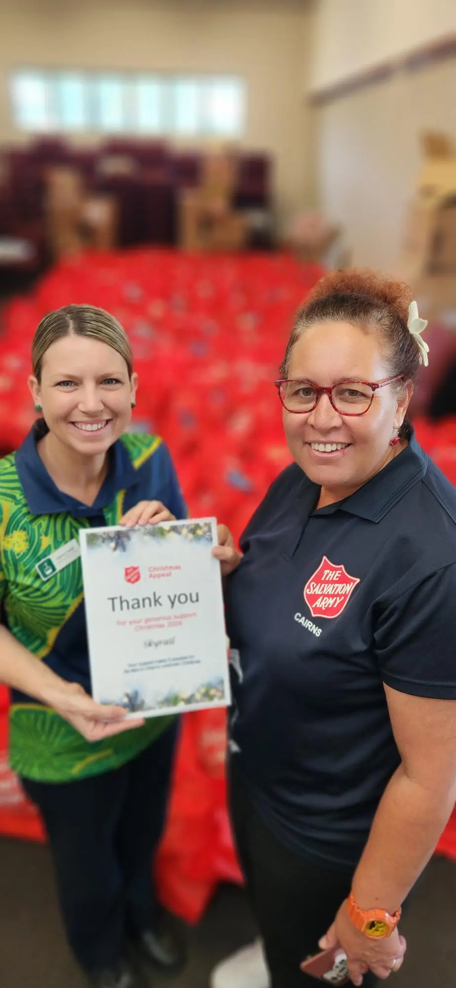 Skyrail Representitive stands with Salvation Army staff to hand over donations