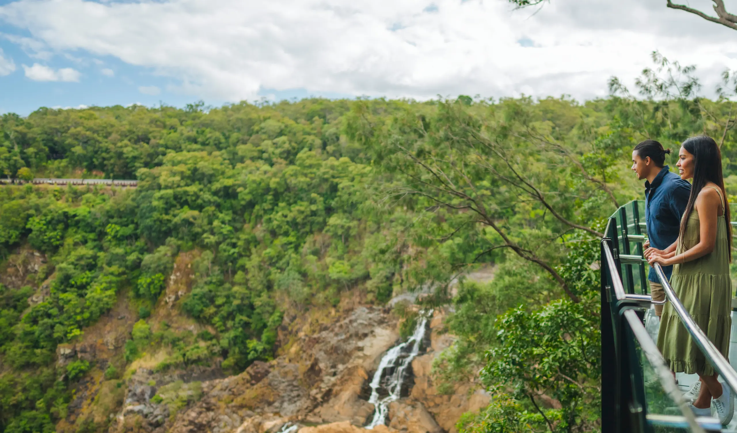 couple looking over the barron gorge towards the barron falls waterfall from Skyrail's The Edge Lookout